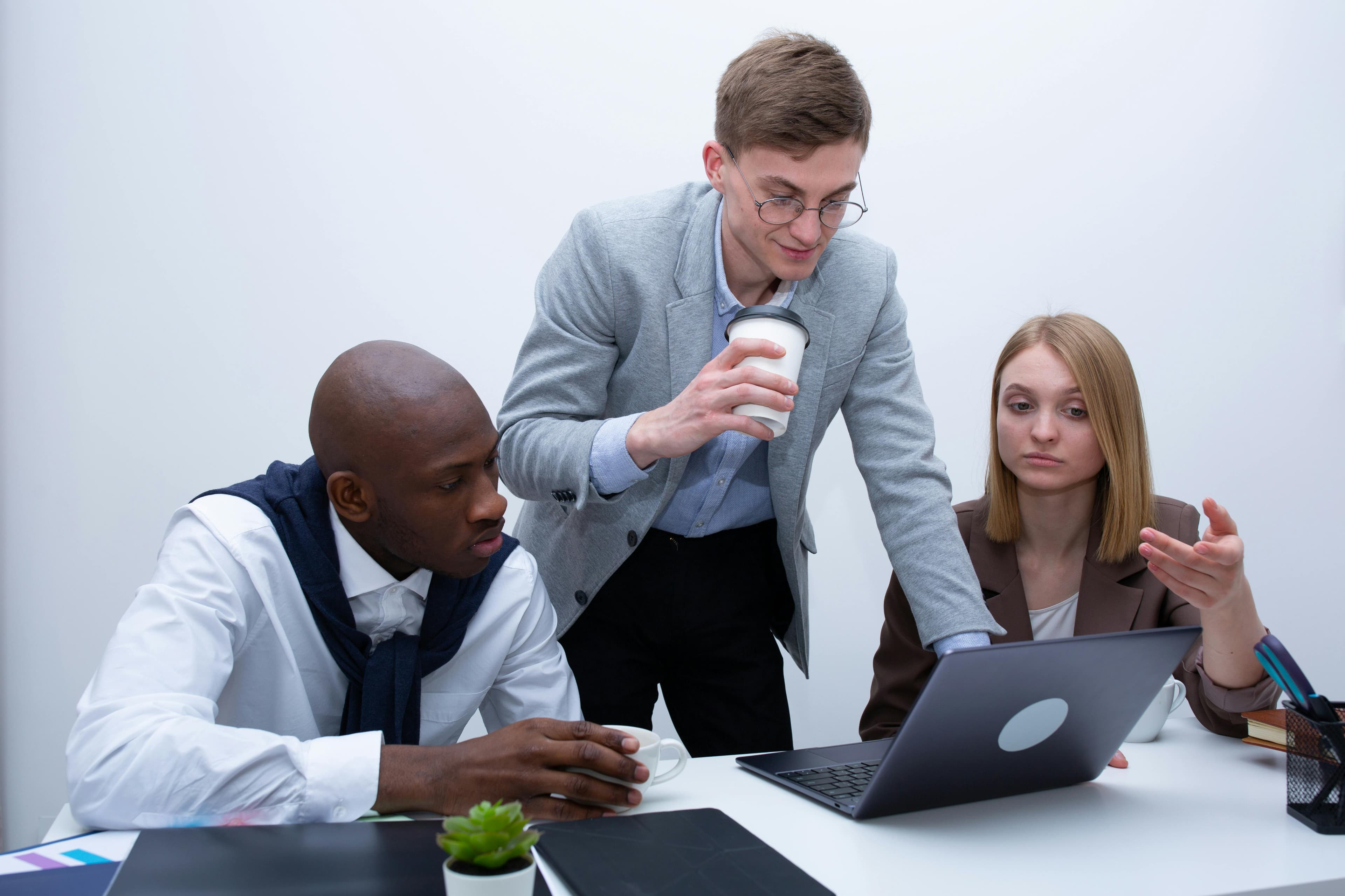 Team members reviewing work together on a laptop