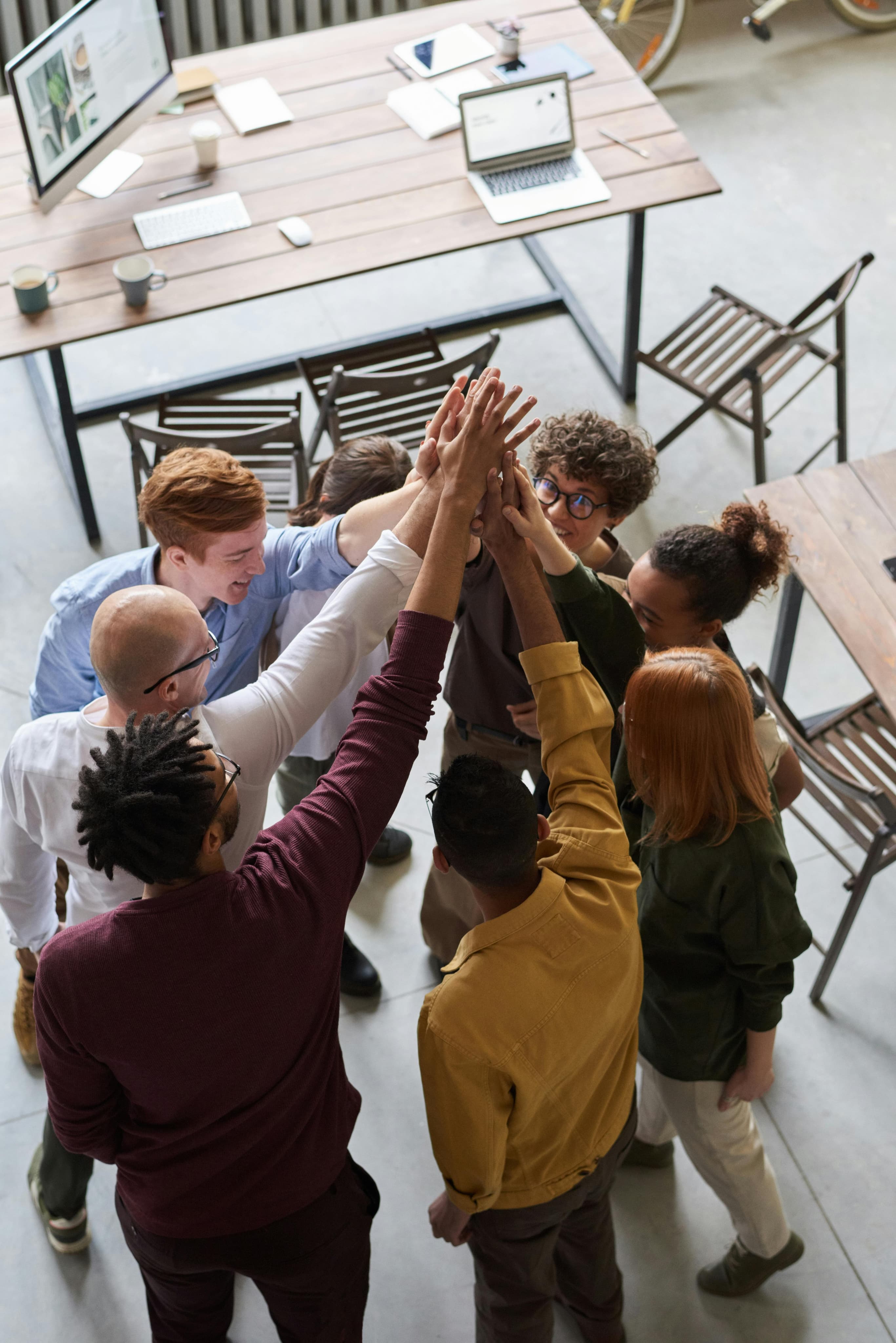 Team members celebrating with a group high-five in the office
